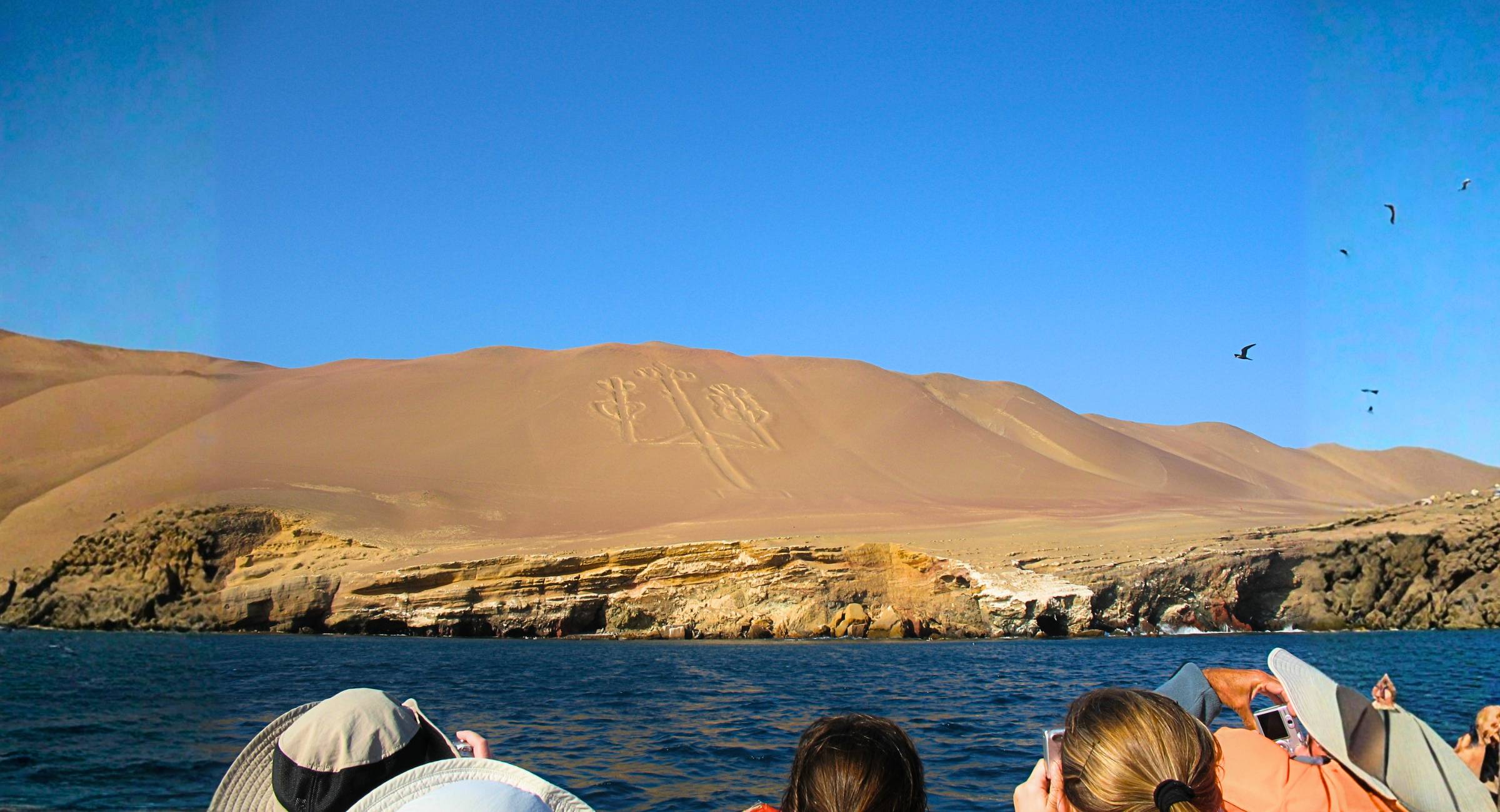 Reisende in einem Boot bestaunen das Scharrbild des Kandelabers von Paracas