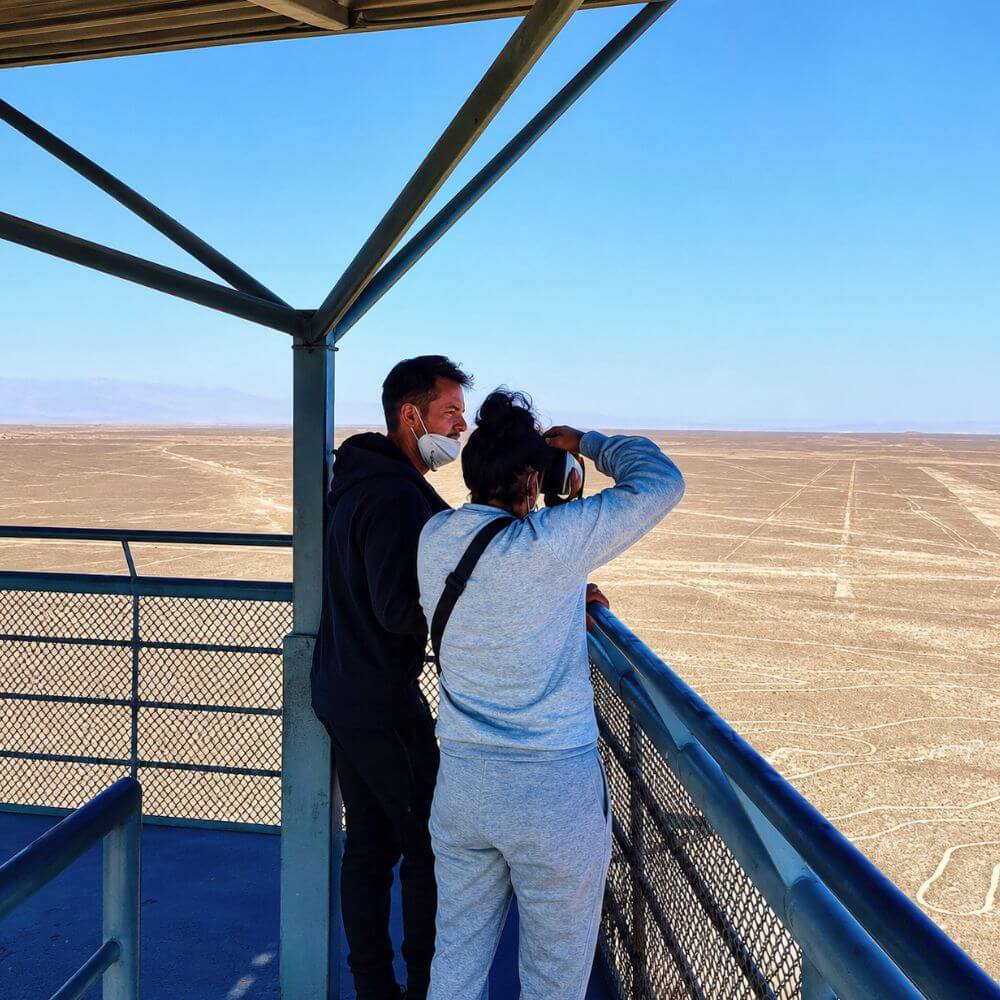 Visitors observing the ancient Nazca Lines from the observation tower in the Nazca Desert of Peru.