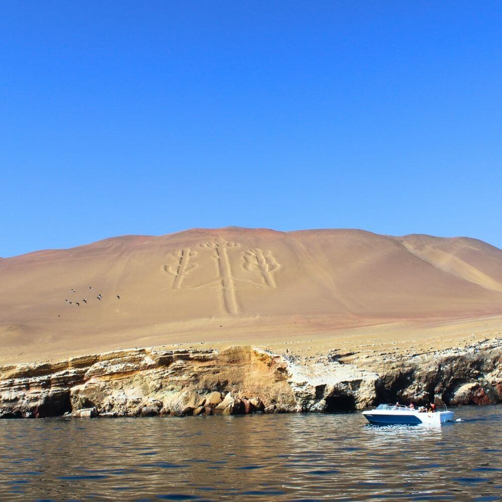 The mysterious Candelabra geoglyph in Paracas viewed during a Ballestas Islands boat tour from Lima, Peru.