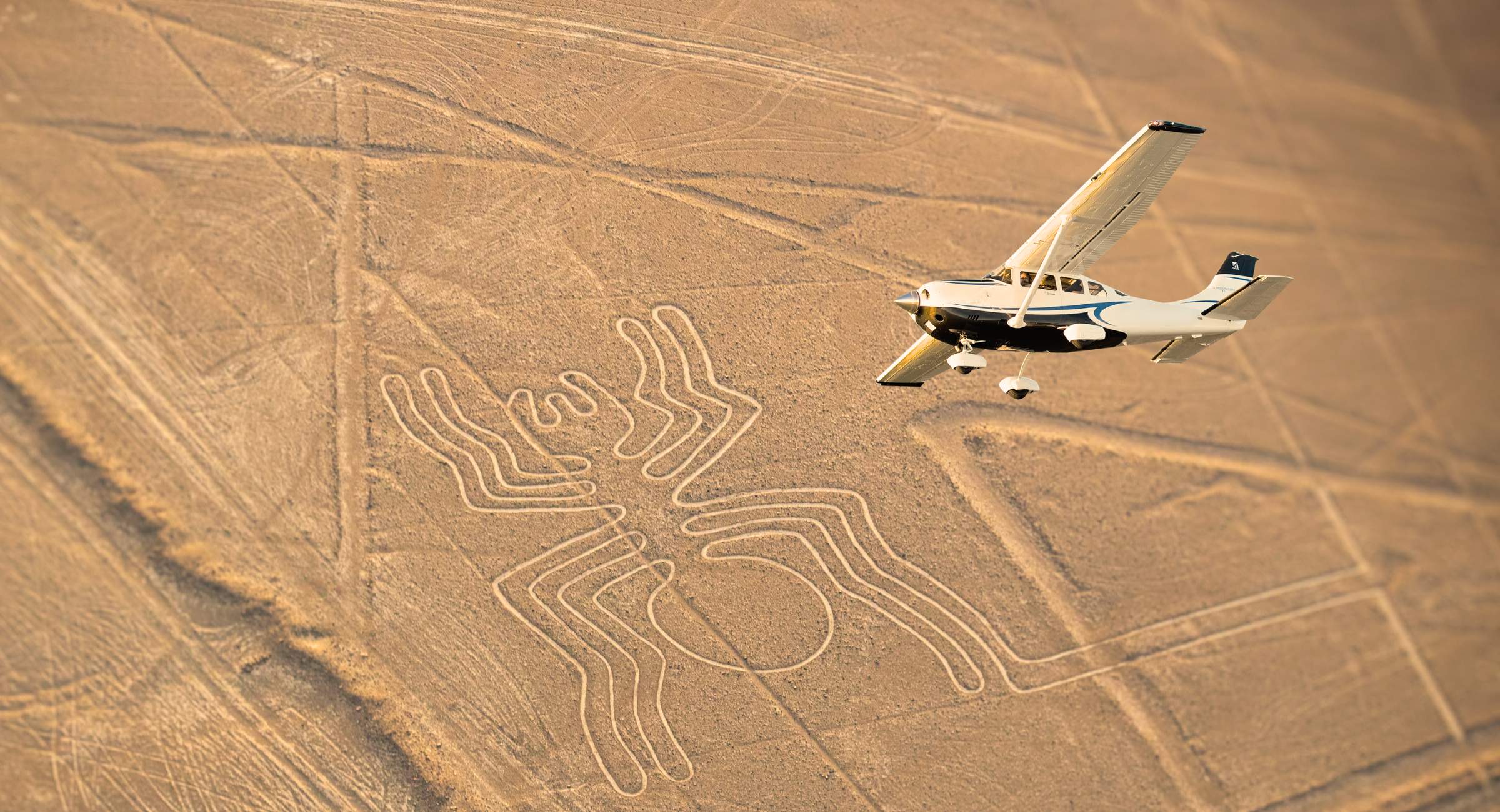 Piccolo aereo in volo sopra il geoglifo del Ragno delle linee di Nazca