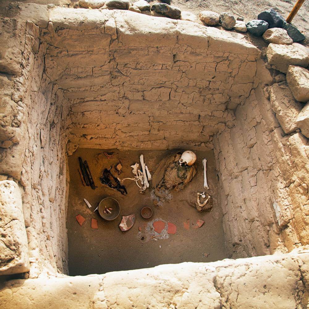 Ancient burial chamber with human remains and funerary objects at the Chauchilla Cemetery in Nazca, Peru.