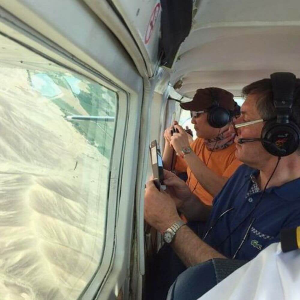 Travelers looking through aircraft windows during a Nazca Lines flight over Peru's UNESCO World Heritage Site.