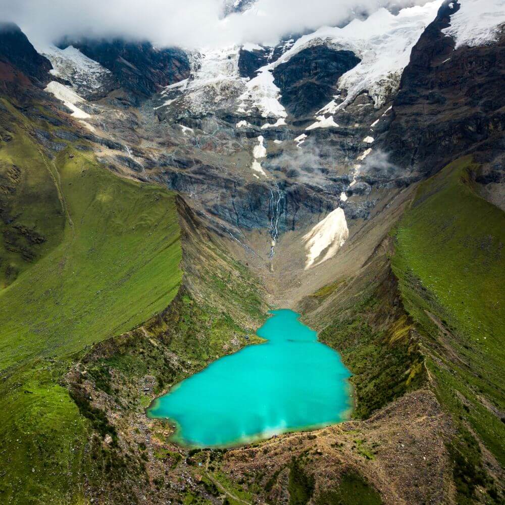 Aerial view of Humantay Lake beneath the towering Humantay Glacier during the Humantay Lake Trek from Cusco, Peru.