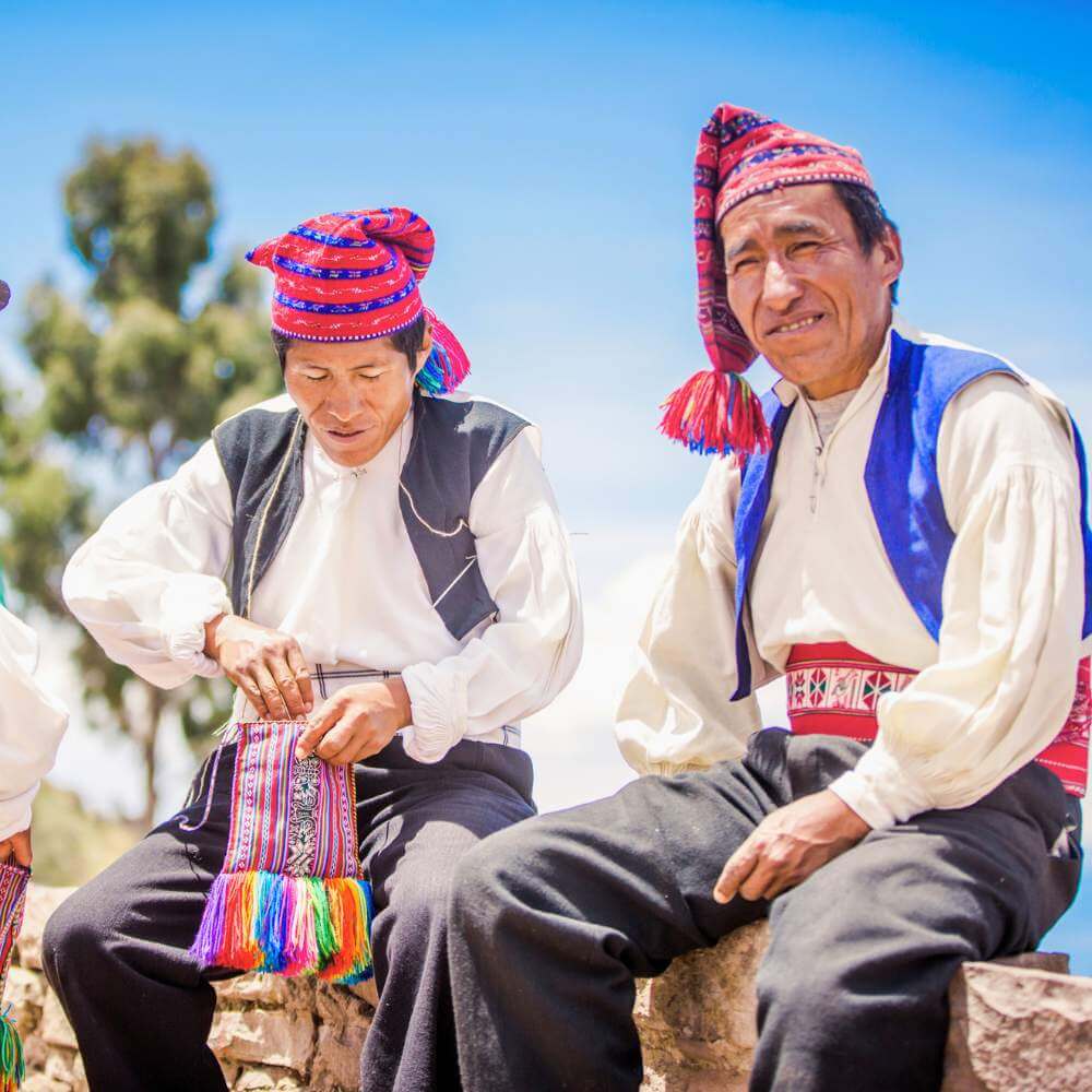 Local artisans weaving traditional textiles on Taquile Island during a Lake Titicaca Full Day Tour in Peru.