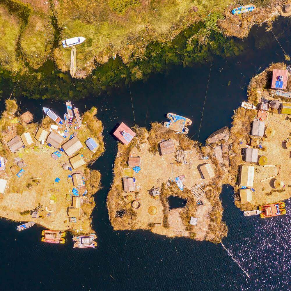 Aerial view of the Uros Floating Islands on Lake Titicaca, showcasing traditional totora reed islands and the unique floating communities of Peru.
