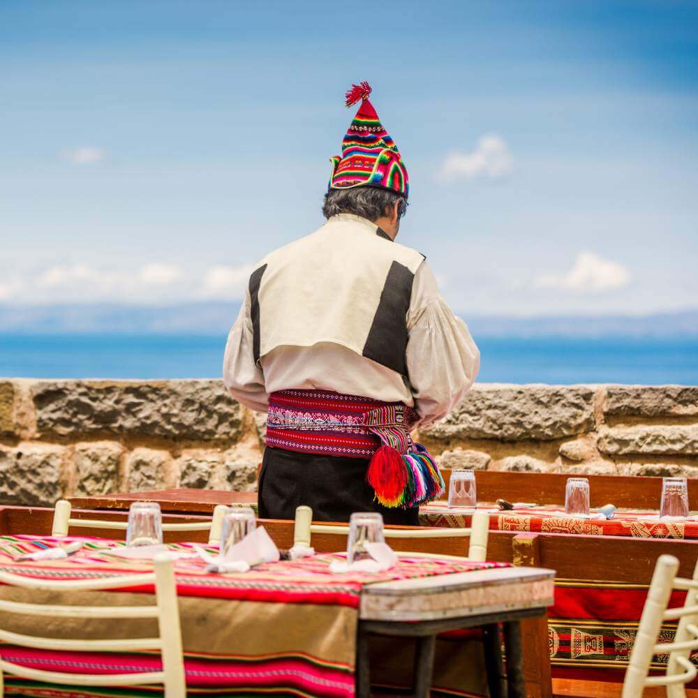 Local host welcoming visitors with traditional Andean hospitality during a Lake Titicaca Homestay Tour on Amantani Island.