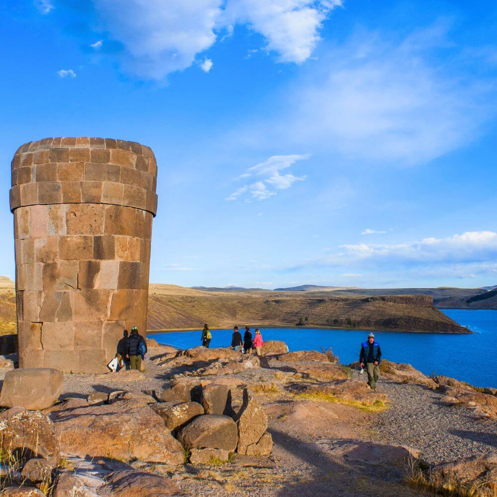 Ancient Sillustani Burial Tower overlooking the crystal-blue waters of Lake Umayo near Puno, Peru, during a private archaeological tour.
