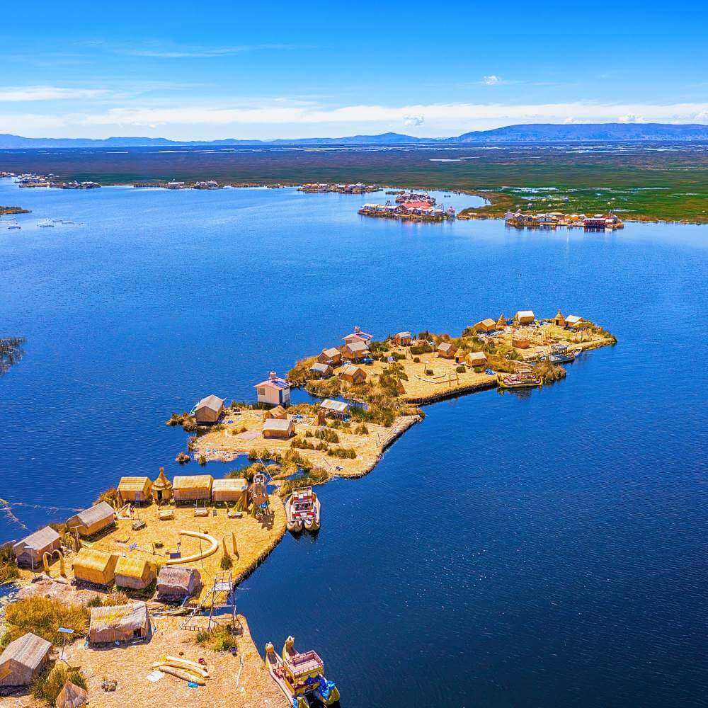 Aerial view of the Uros Floating Islands on Lake Titicaca, Peru, showcasing traditional reed islands surrounded by crystal-clear Andean waters.