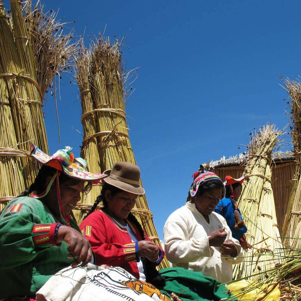 Uros local families weaving traditional textiles on the floating islands of Lake Titicaca during a cultural tour in Peru.