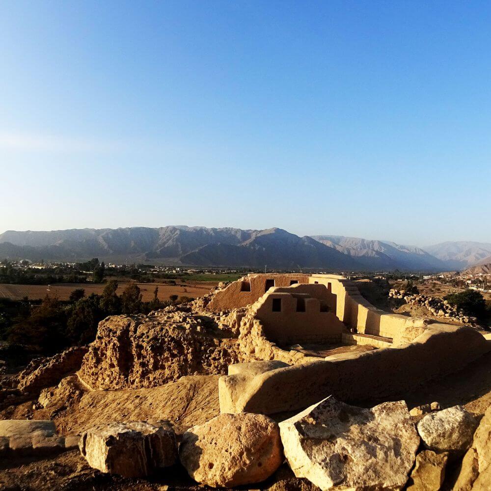 Ancient adobe and stone structures at Los Paredones archaeological site near Nazca, Peru, overlooking the fertile Nazca Valley.