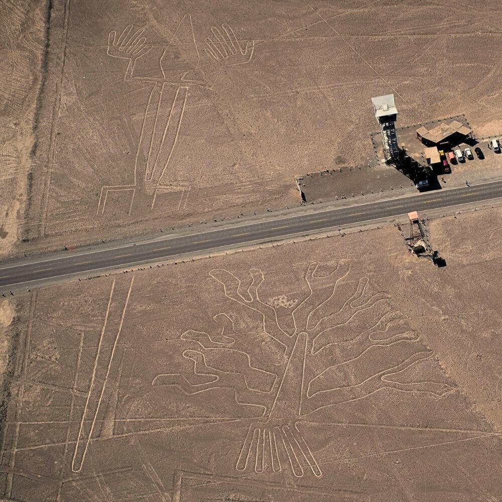 Aerial view of the Nazca Lines observation tower and the famous Tree and Hands geoglyphs along the Pan-American Highway.