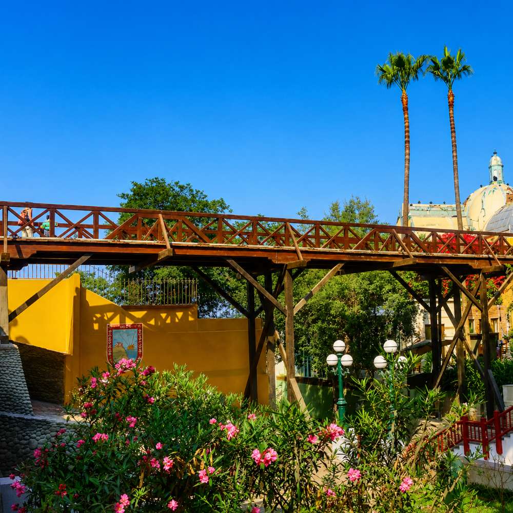 Historic Bridge of Sighs surrounded by gardens and palm trees in the artistic district of Barranco, Lima, Peru.