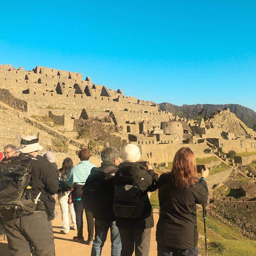 Travelers exploring Machu Picchu with a private English-speaking guide during a guided tour