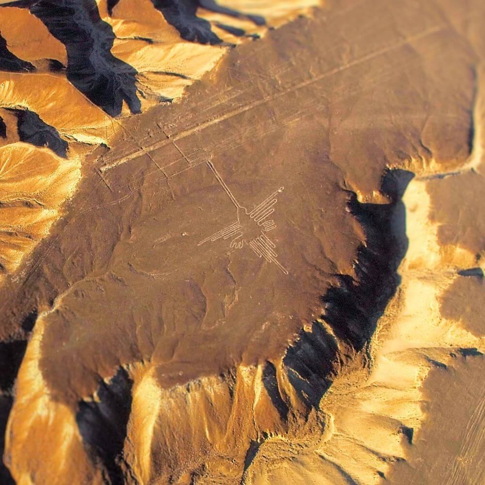 Spectacular aerial view of the Hummingbird geoglyph among the Nazca Lines in Peru's desert landscape.