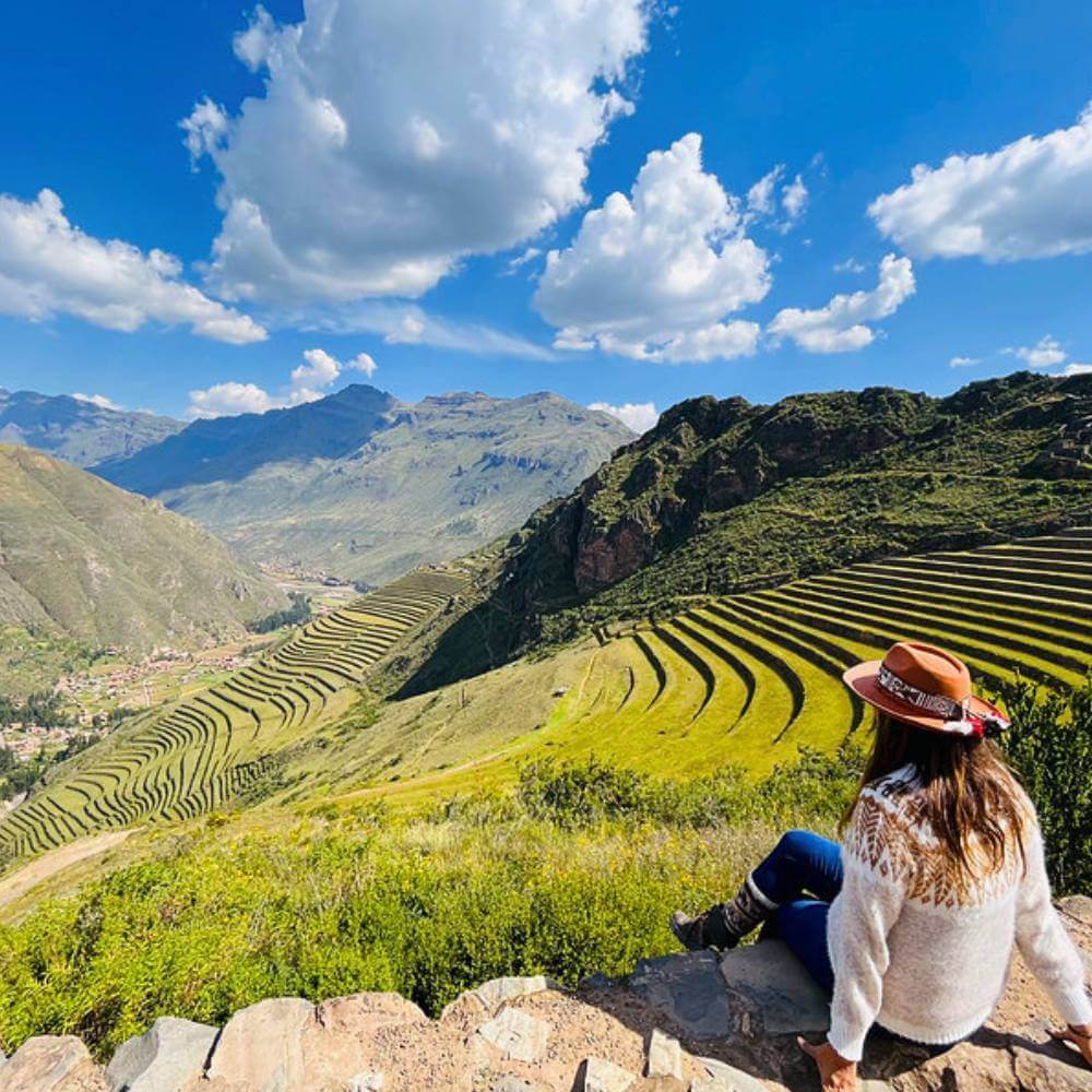 Traveler admiring the impressive Inca terraces of Pisac overlooking the Sacred Valley of Peru.