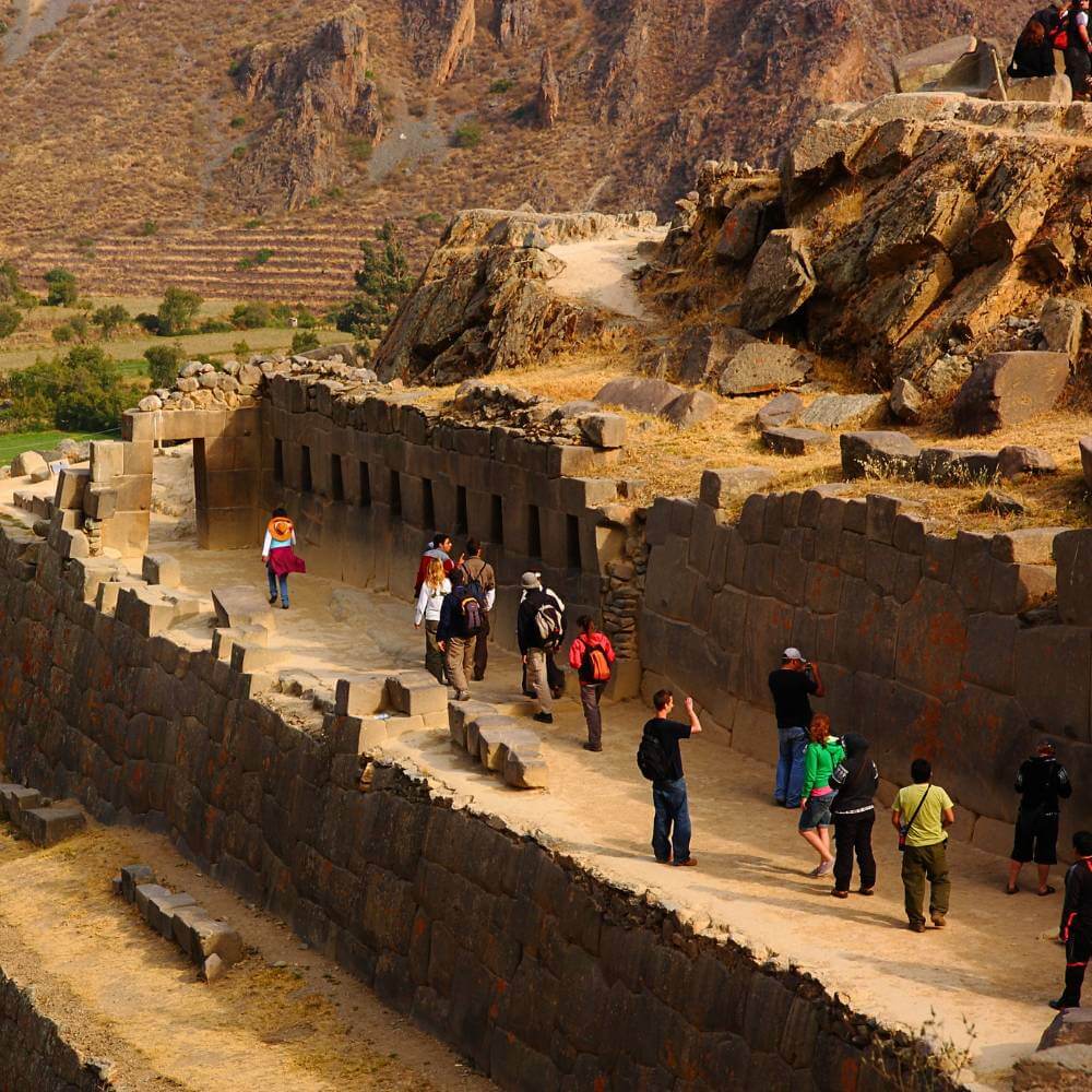 Visitors exploring the monumental stone terraces and ceremonial structures of Ollantaytambo Fortress.
