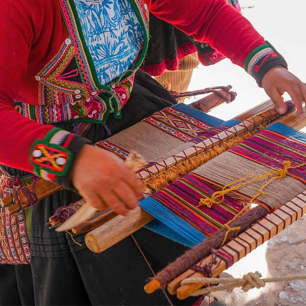 Close-up of a traditional weaving demonstration in Chinchero showcasing ancient Andean textile techniques and natural dyes.