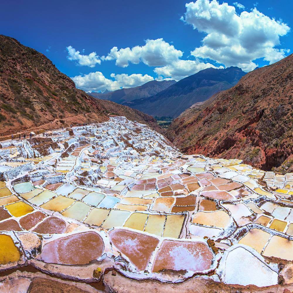 Panoramic view of the Maras Salt Mines with thousands of salt terraces cascading through the Sacred Valley near Cusco.