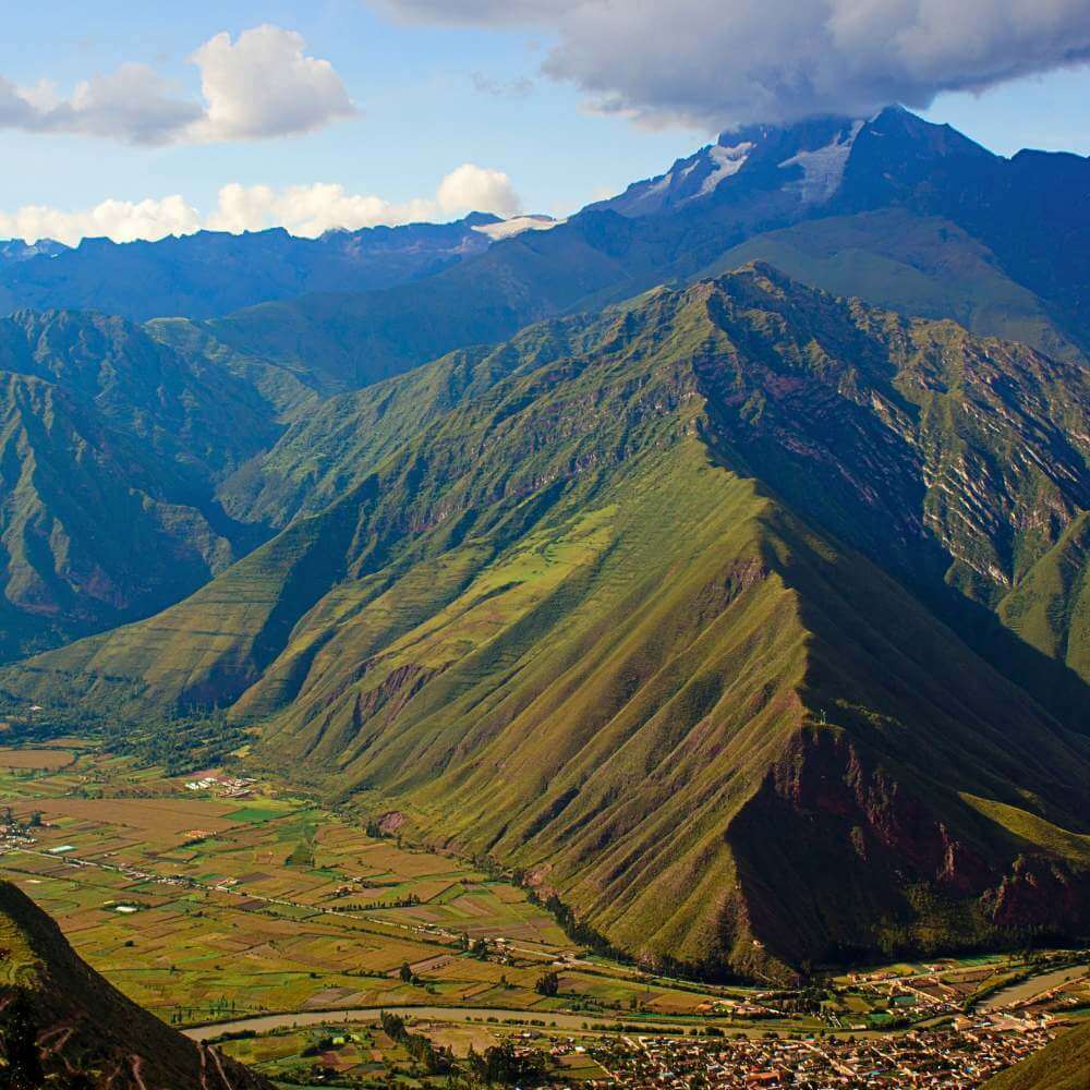 Spectacular panoramic landscape of the Sacred Valley surrounded by towering Andean mountains near Cusco, Peru.