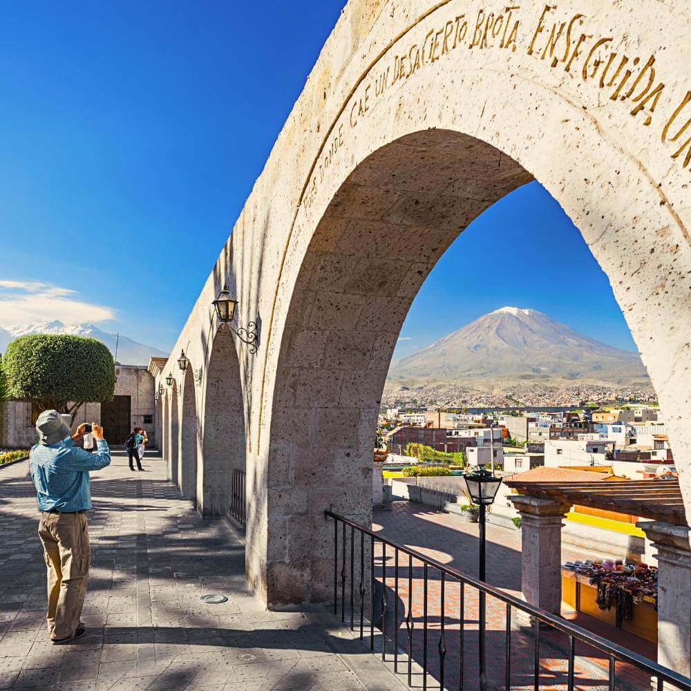 Tourist enjoying panoramic views of Misti Volcano from the famous Yanahuara Viewpoint during a private City Tour of Arequipa.