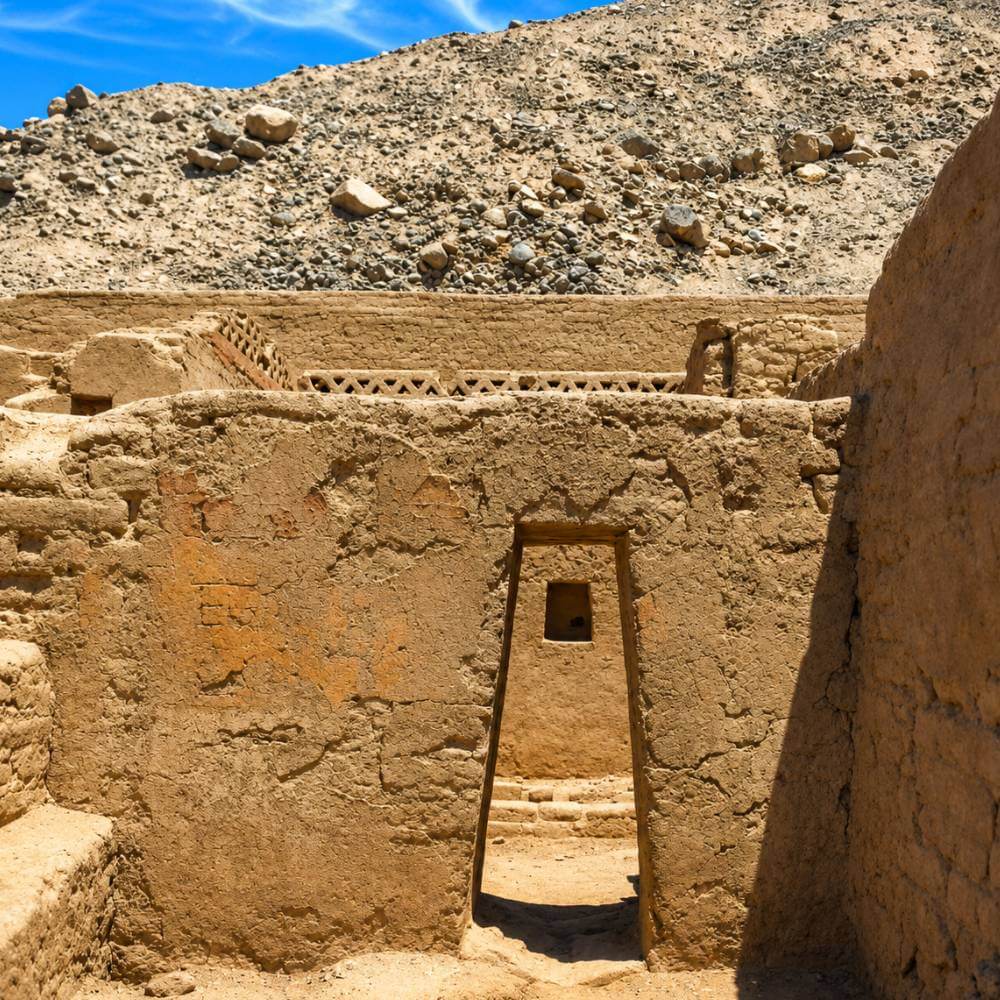 Historic Inca doorway inside Tambo Colorado featuring original adobe walls and traditional trapezoidal architecture in Peru.