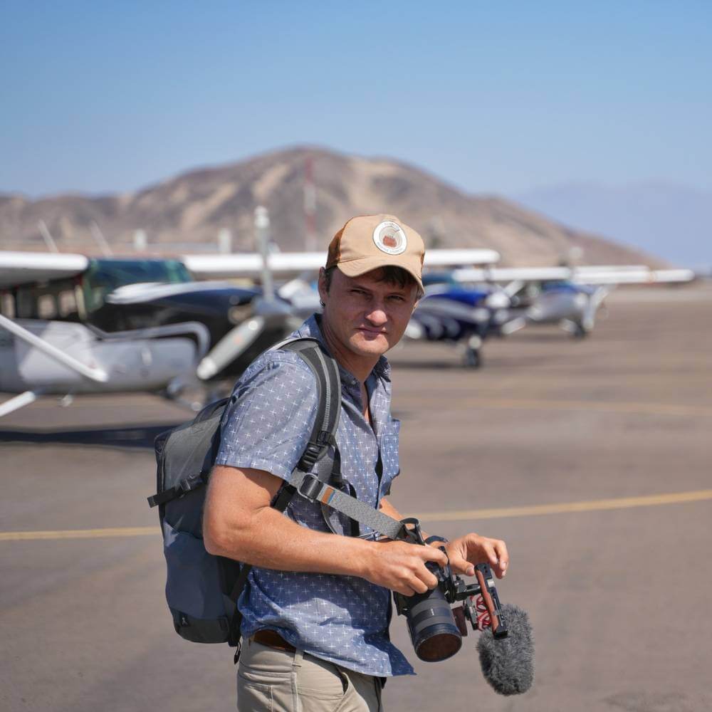 Traveler preparing for a Nazca Palpa Lines Flight at Nazca Airport with sightseeing aircraft in the background.