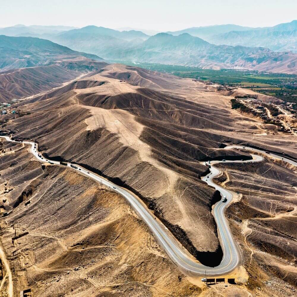 Winding desert highway crossing the dry mountains between Ica and Nazca in southern Peru.