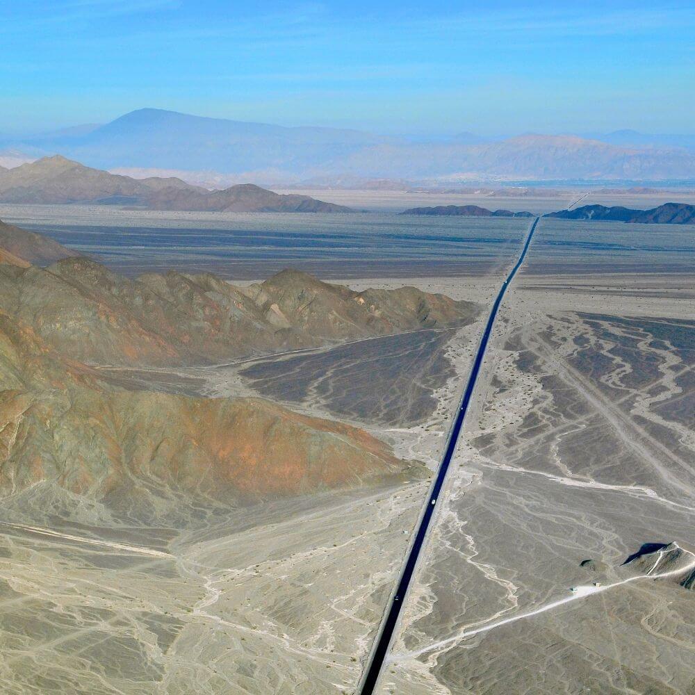 Aerial view of the Pan-American Highway crossing the vast Nazca desert landscape.