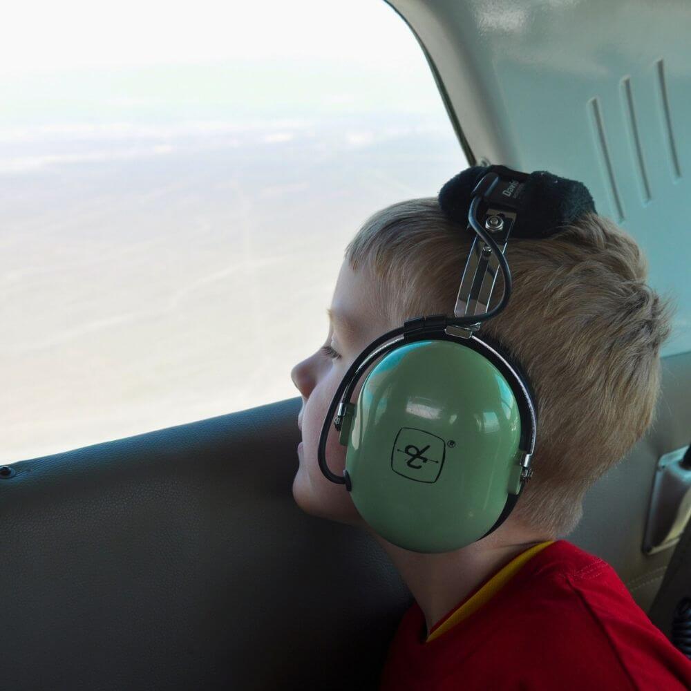 Young passenger looking out the airplane window during a Nazca Lines sightseeing flight.