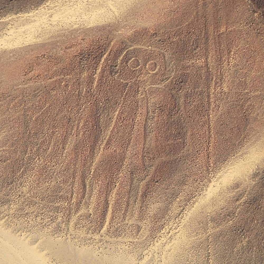 Close aerial view of the famous Astronaut geoglyph carved into a desert hillside near Nazca.