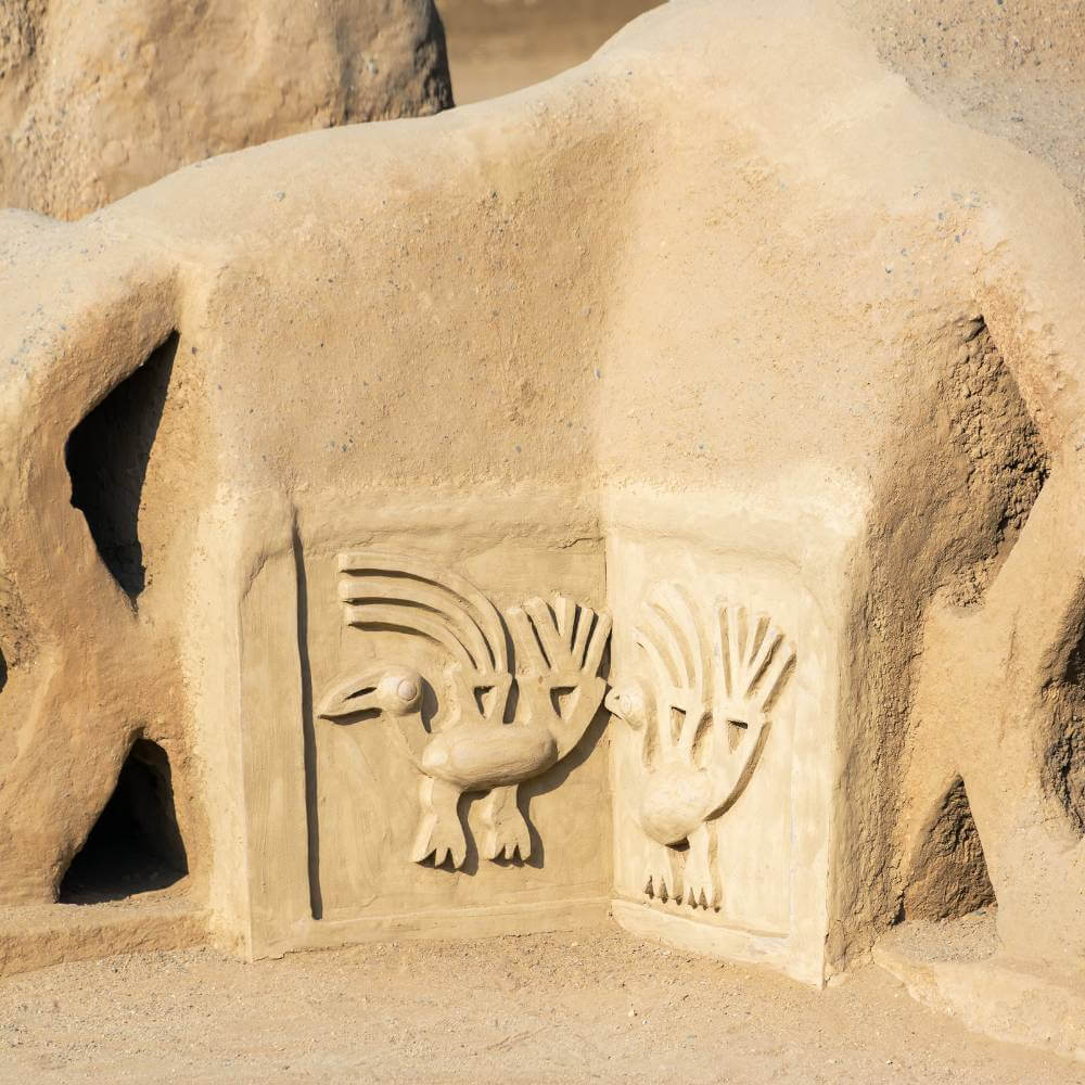Ancient Chimú bird friezes carved into adobe walls at Chan Chan Ruins, showcasing remarkable pre-Inca artistry in northern Peru