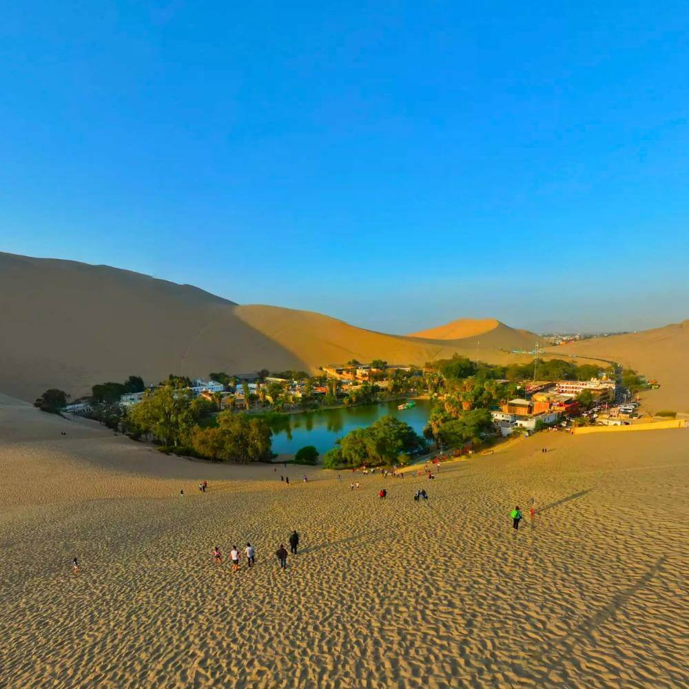 Panoramic view of the Huacachina Oasis surrounded by towering sand dunes in southern Peru during the Huacachina Dune Buggy Tour.