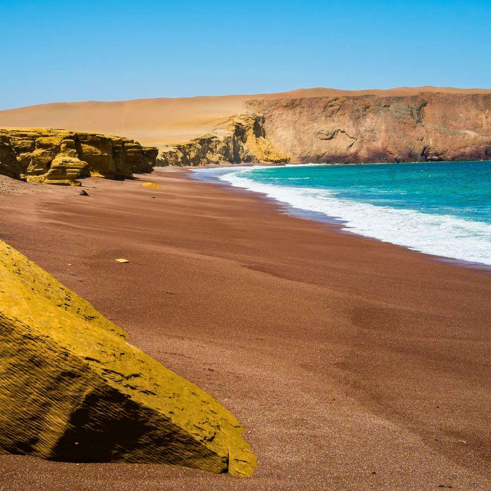 Red Beach (Playa Roja) with its unique crimson sand inside the Paracas National Reserve during a Paracas Bay Tour.