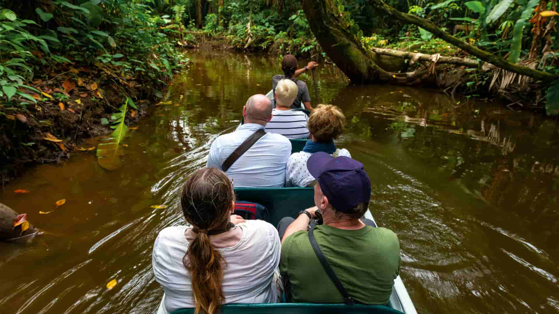 Reisende in einem Boot auf einem Fluss im peruanischen Amazonasgebiet