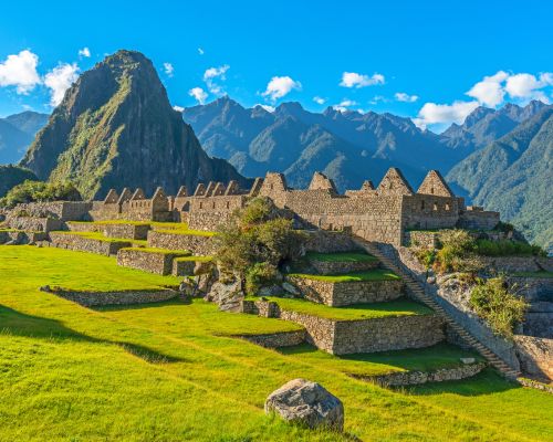 Panoramic view of Machu Picchu surrounded by misty mountains.
