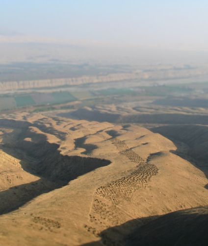 Aerial view of the mysterious Band Holes in Monte Sierpe, an ancient formation of perfectly aligned cavities carved into the desert hillside of the Pisco Valley.