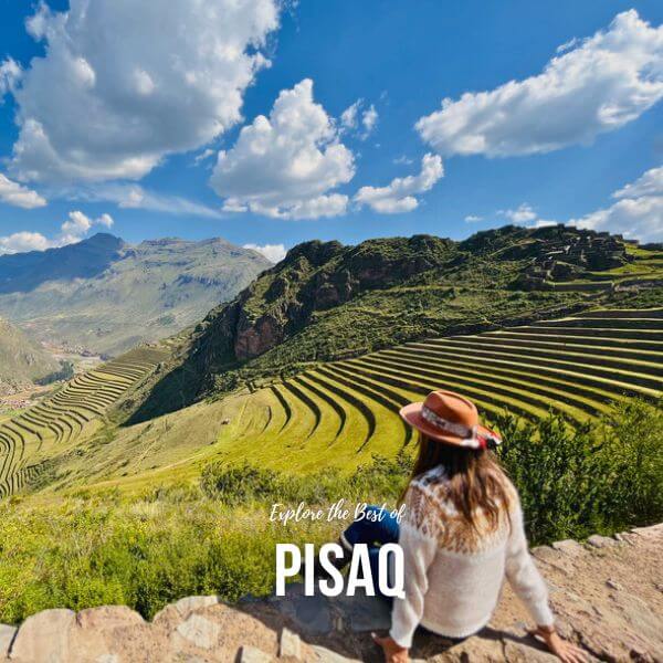 Panoramic view of the Pisaq Inca ruins with agricultural terraces and mountain backdrop.