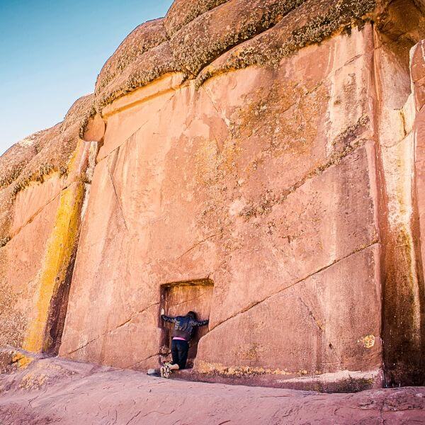 Tourist kneeling and touching the Amaru Muru portal.