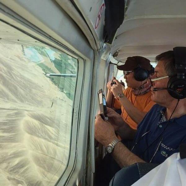 Tourist photographing Nazca Lines from the airplane window.