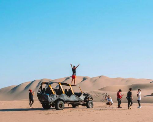 Tourists taking photos in the Paracas desert dunes