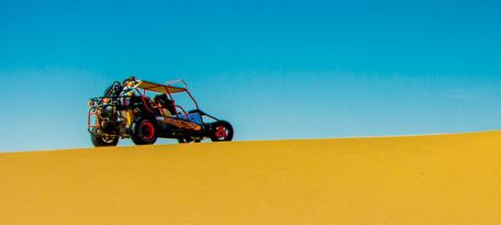 Desert buggy climbing a high dune near Paracas.