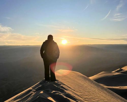 Solo traveler admiring sunrise on Cerro Blanco