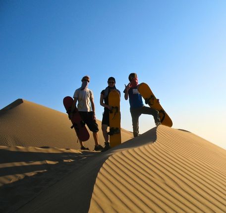 Sandboarders camping on Cerro Blanco, ready for dune adventure