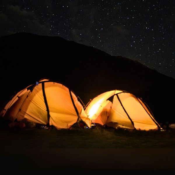 Glowing tents at night during Camping Tour on Cerro Blanco under starry skies