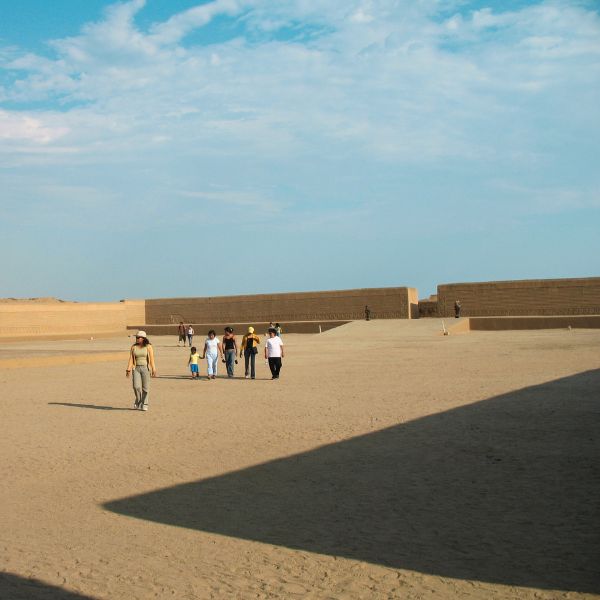 Visitors exploring the vast ceremonial plaza of Chan Chan ruins