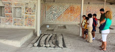 Tourists observing skeletal remains and murals
