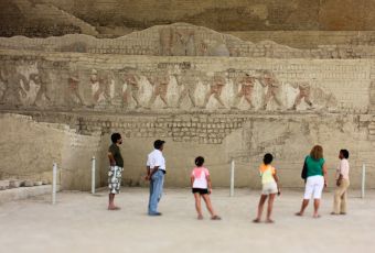 Visitors observing ancient friezes at the El Brujo archaeological complex