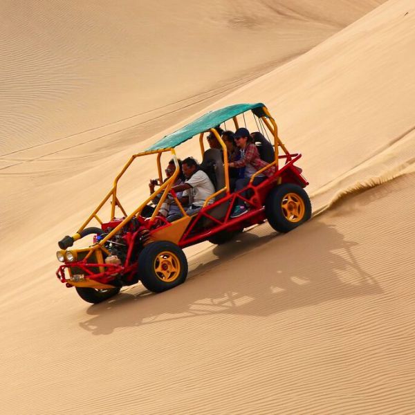 Dune buggy racing down the golden dunes of Huacachina