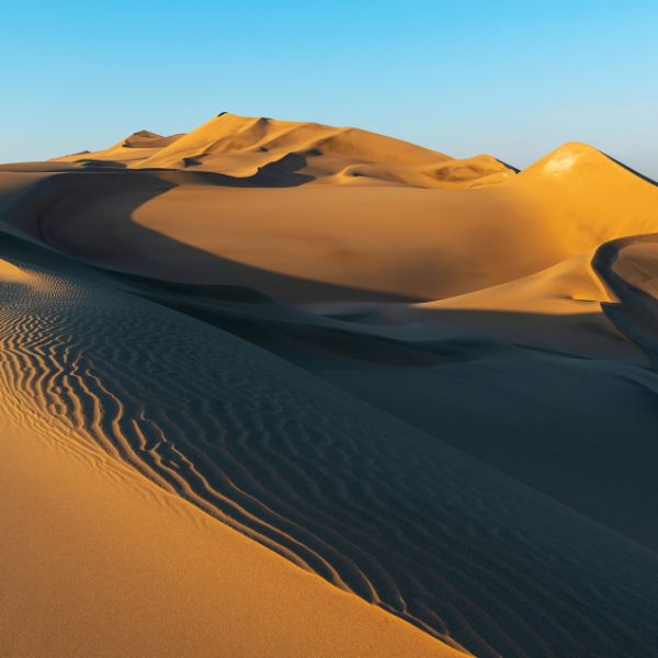 Stunning golden sand dunes at sunset in Huacachina