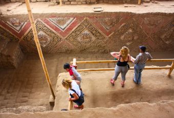 Tourists exploring murals at the Temple of the Moon in Trujillo